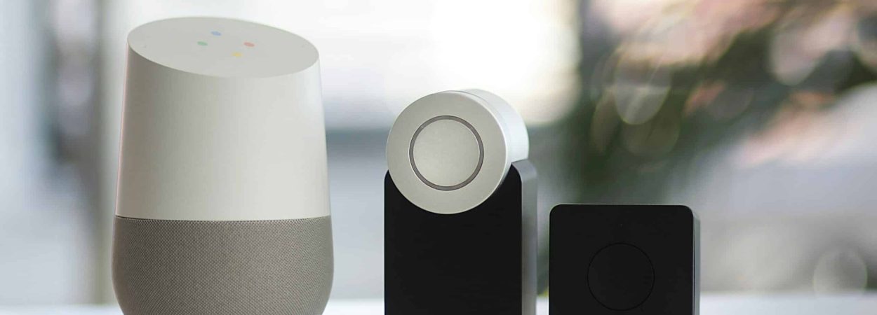 white and gray Google smart speaker and wo black speakers